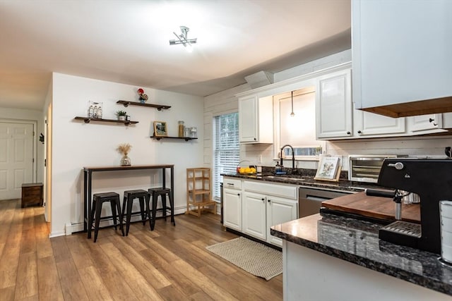 kitchen with a baseboard heating unit, white cabinetry, dishwasher, and sink