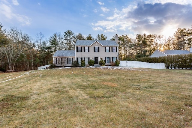 colonial-style house featuring a front lawn