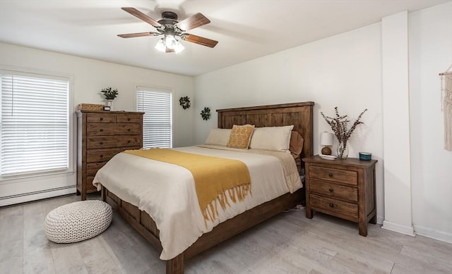 bedroom featuring multiple windows, a baseboard radiator, light hardwood / wood-style floors, and ceiling fan