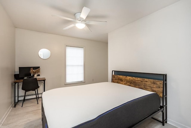 bedroom with a baseboard heating unit, ceiling fan, and light wood-type flooring