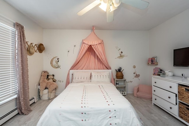 bedroom with a baseboard radiator, light hardwood / wood-style floors, and ceiling fan