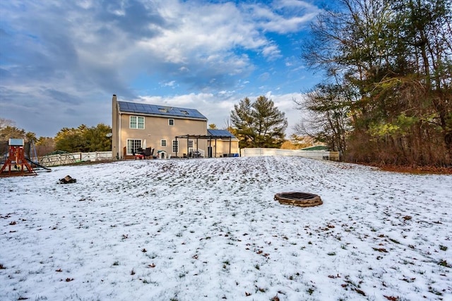 exterior space featuring a playground, a fire pit, and solar panels