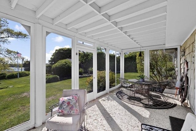 sunroom / solarium with healthy amount of natural light, beamed ceiling, outdoor dining area, and french doors