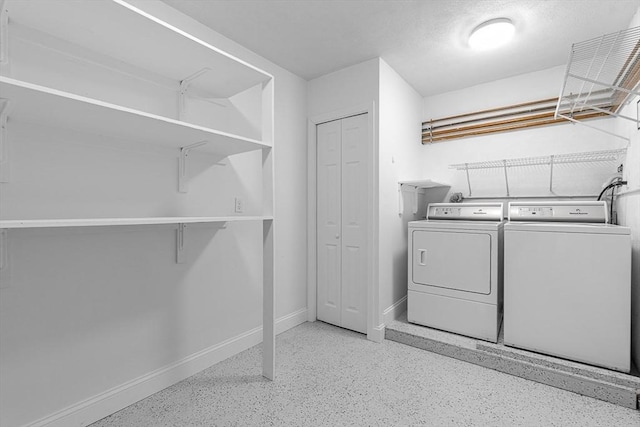laundry area featuring washing machine and dryer and baseboards