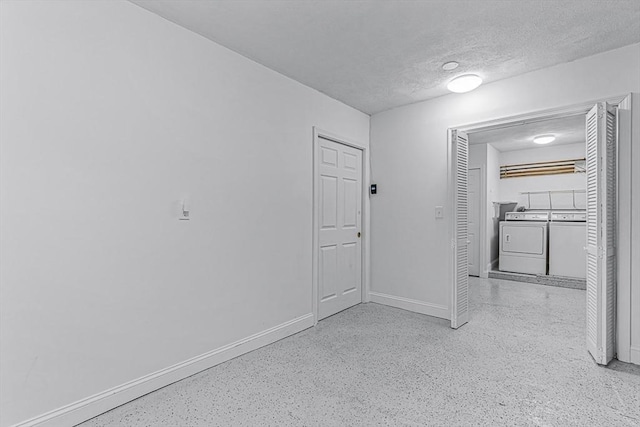 unfurnished bedroom featuring separate washer and dryer, a textured ceiling, baseboards, and speckled floor