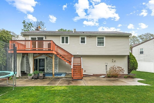rear view of house with stairs, a patio area, a trampoline, and a wooden deck