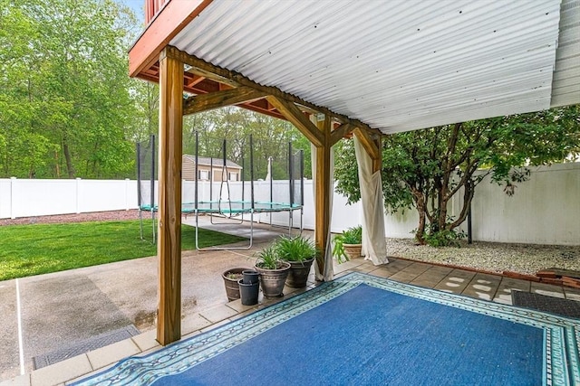 view of swimming pool featuring a patio, a trampoline, and a fenced backyard