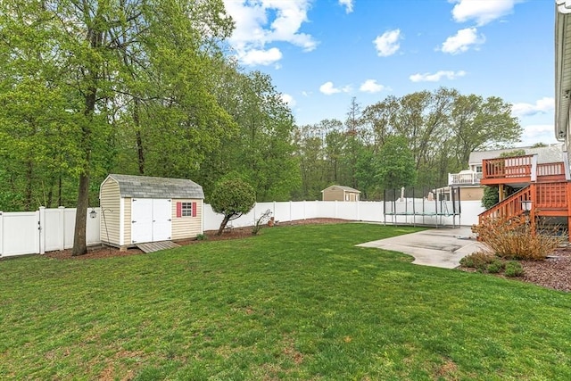 view of yard featuring a trampoline, a storage shed, an outdoor structure, stairway, and a wooden deck