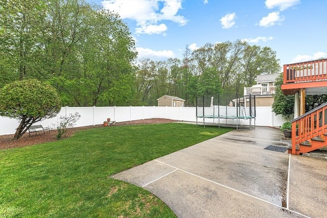view of yard with a trampoline, a patio area, stairway, and a deck