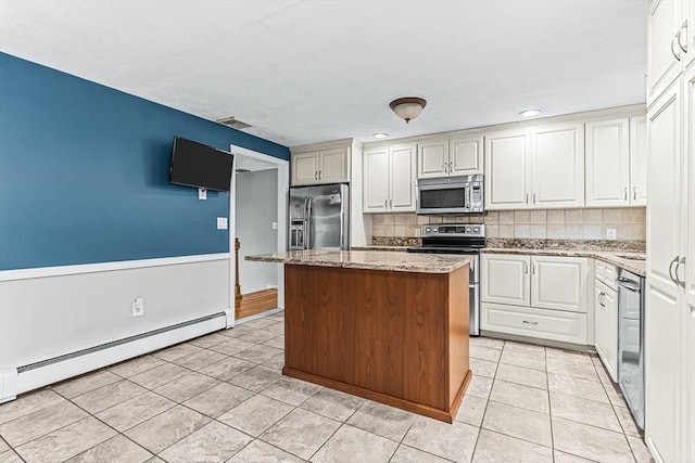 kitchen featuring stainless steel appliances, light tile patterned floors, baseboard heating, decorative backsplash, and a center island