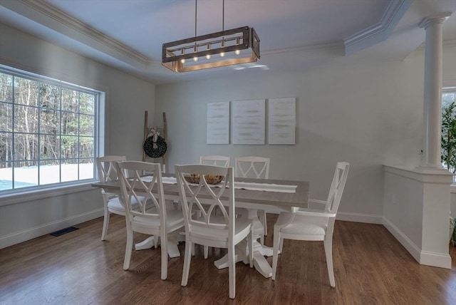 dining space with ornate columns, crown molding, hardwood / wood-style flooring, and a tray ceiling