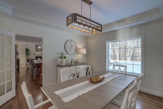 dining space with dark hardwood / wood-style flooring and ornamental molding