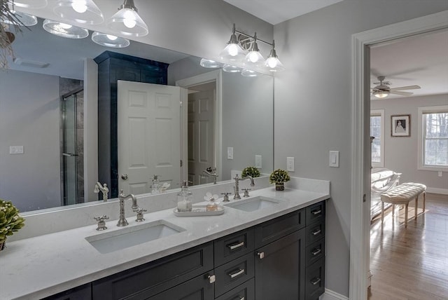 bathroom with vanity, hardwood / wood-style flooring, a shower with shower door, and ceiling fan