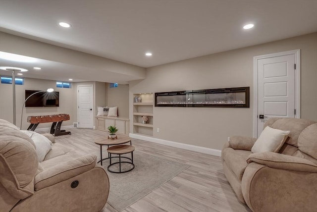 living room featuring built in features and light wood-type flooring