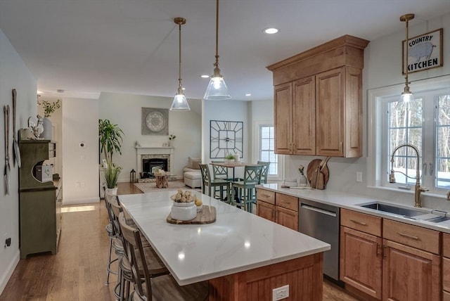 kitchen with sink, dishwasher, hanging light fixtures, a center island, and a kitchen bar