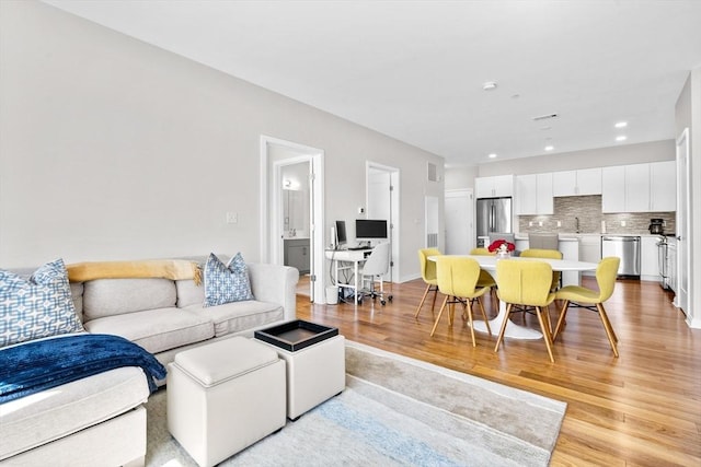 living room featuring light hardwood / wood-style floors and sink