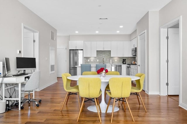 kitchen featuring a kitchen breakfast bar, white cabinets, a center island, and stainless steel appliances