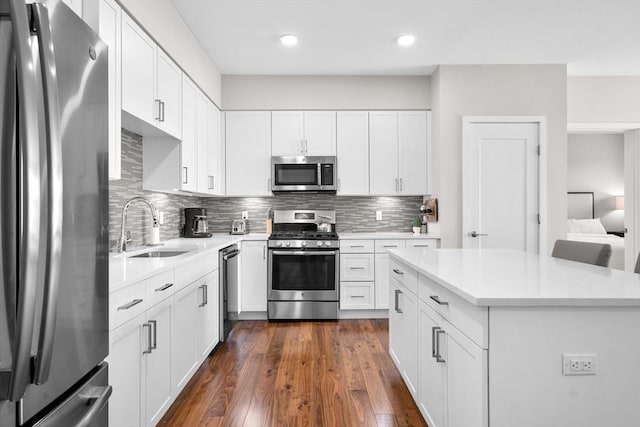 kitchen with sink, white cabinets, appliances with stainless steel finishes, and tasteful backsplash