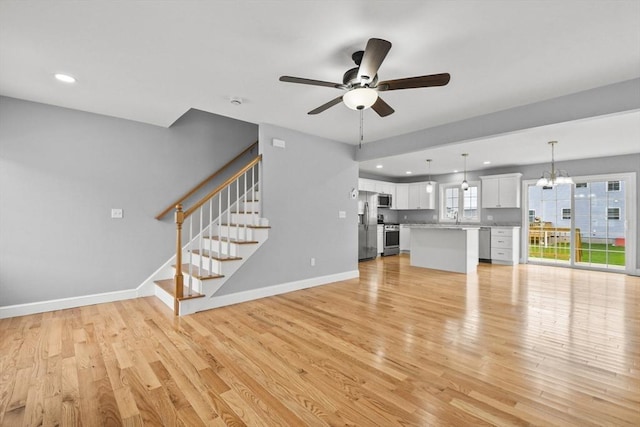 218 Tuttle St, Fall River, MA 02724 - unfurnished living room featuring ceiling fan, light wood finished floors, stairway, a chandelier, and recessed lighting