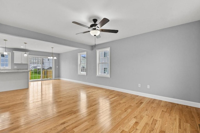 218 Tuttle St, Fall River, MA 02724 - unfurnished living room featuring ceiling fan, light wood-style floors, and a chandelier
