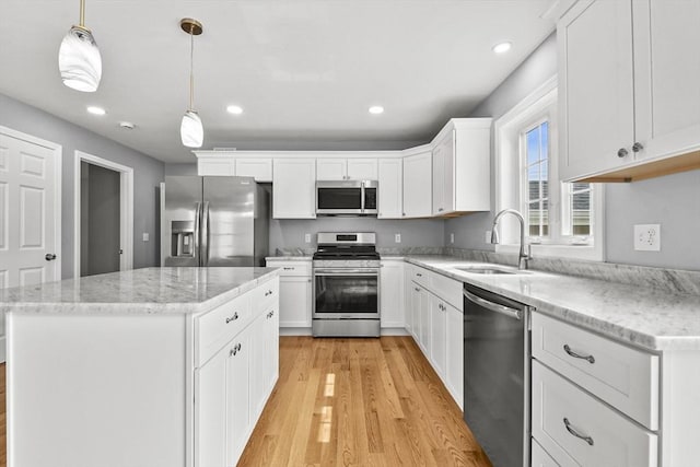 218 Tuttle St, Fall River, MA 02724 - kitchen with stainless steel appliances, light wood-type flooring, a kitchen island, recessed lighting, and white cabinetry