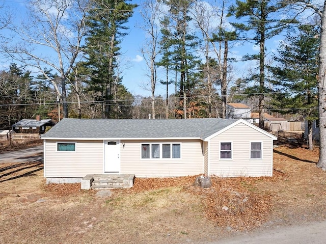 view of front of home featuring a shingled roof and fence