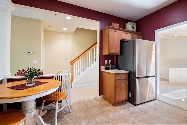 kitchen featuring stainless steel fridge, ornamental molding, and light carpet