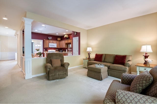 living room featuring ornate columns and light colored carpet