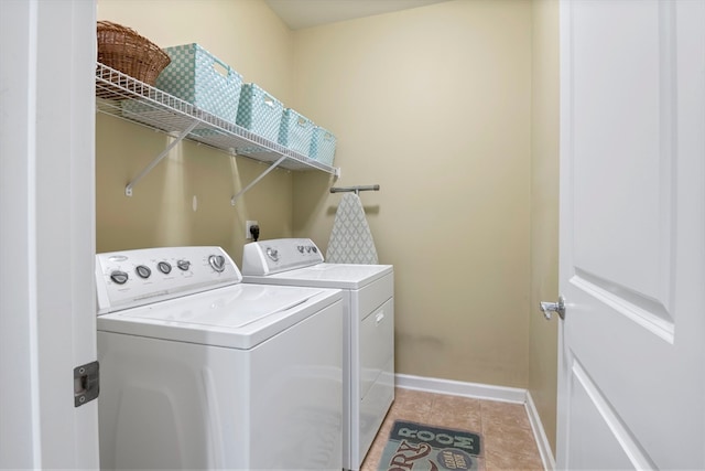 washroom featuring washing machine and dryer and light tile patterned floors