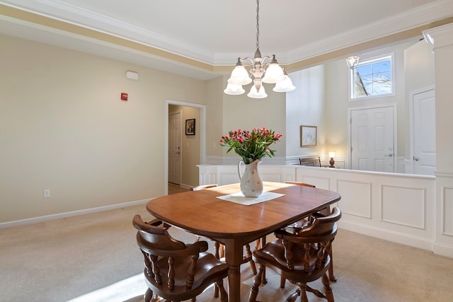 dining area featuring a notable chandelier, light colored carpet, and ornamental molding