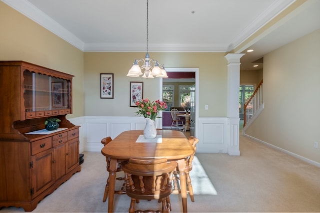 dining area featuring a notable chandelier, crown molding, light carpet, and decorative columns