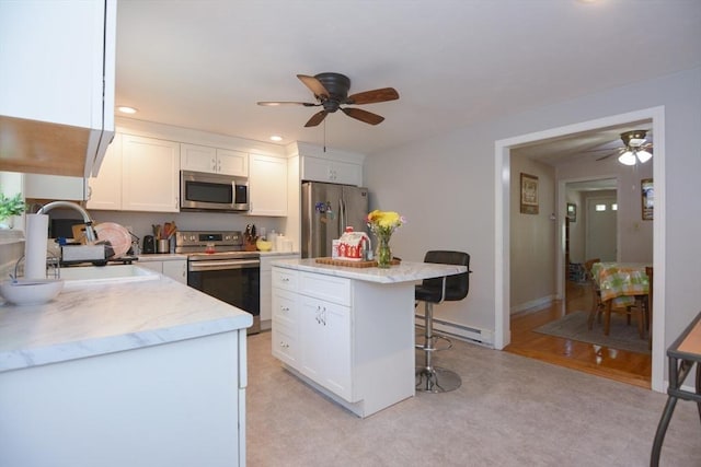 6 Ayrshire Rd, Worcester, MA 01604 - kitchen with stainless steel appliances, a ceiling fan, a breakfast bar area, a baseboard heating unit, and recessed lighting
