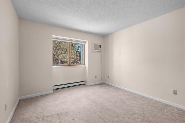 53 Chilton Ln Unit 53, Brewster, MA 02631 - empty room featuring a textured ceiling, carpet floors, a wall mounted AC, a baseboard heating unit, and baseboards