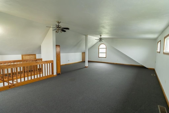 bonus room featuring dark colored carpet, ceiling fan, and lofted ceiling