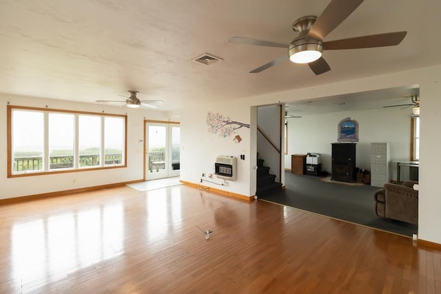 unfurnished living room featuring heating unit and light hardwood / wood-style floors