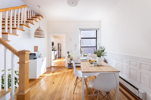 499 Beacon St, Boston, MA 02215 - dining space featuring stairway, light wood-style floors, and a baseboard radiator