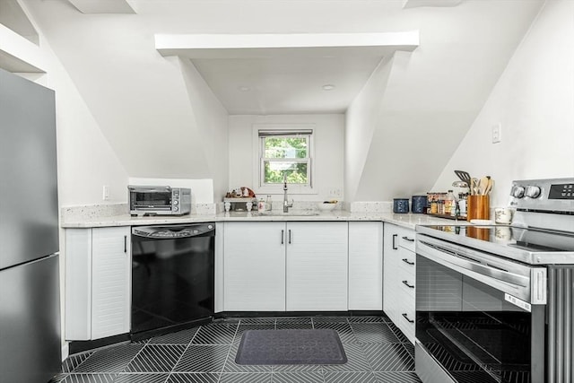 kitchen featuring stainless steel appliances, a sink, light stone countertops, dark tile patterned flooring, and white cabinetry