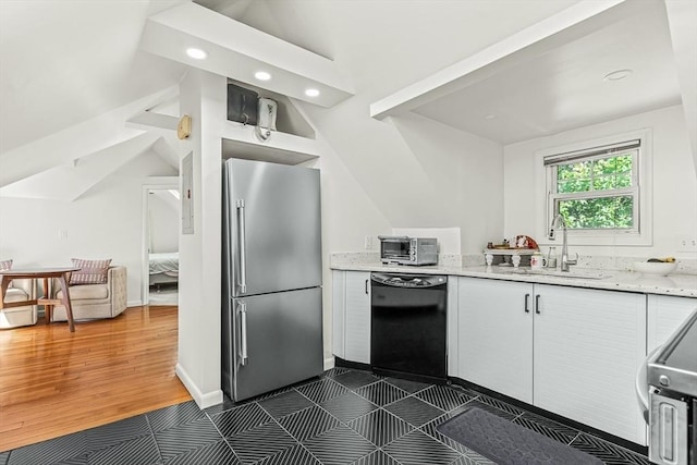 kitchen featuring freestanding refrigerator, black dishwasher, a sink, white cabinets, and recessed lighting