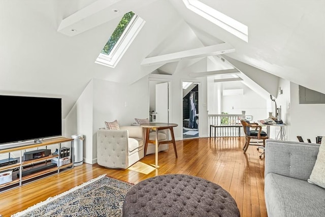 living room with a skylight, hardwood / wood-style floors, a wall unit AC, and high vaulted ceiling