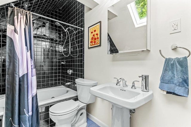 bathroom with a skylight, tiled shower / bath, toilet, and baseboards