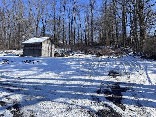 yard layered in snow featuring an outbuilding