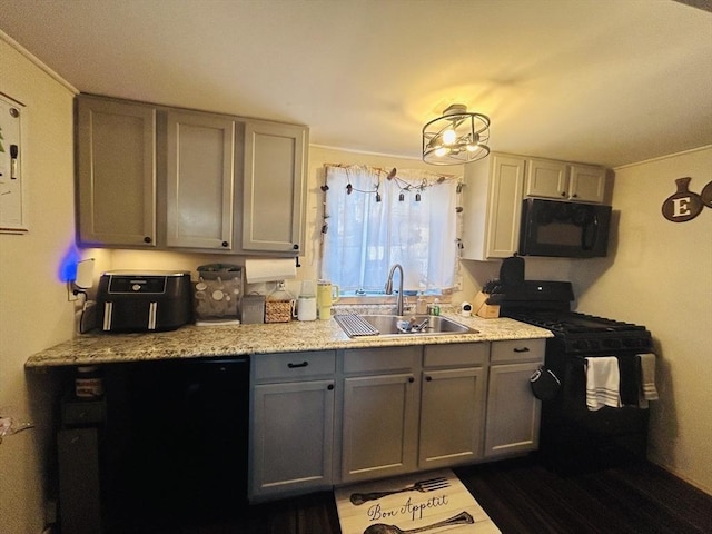 kitchen with gray cabinets, sink, light stone counters, and black appliances