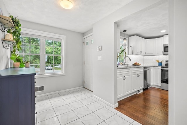 21 Forest St, Wilmington, MA 01887 - kitchen with appliances with stainless steel finishes, baseboards, white cabinetry, tasteful backsplash, and recessed lighting