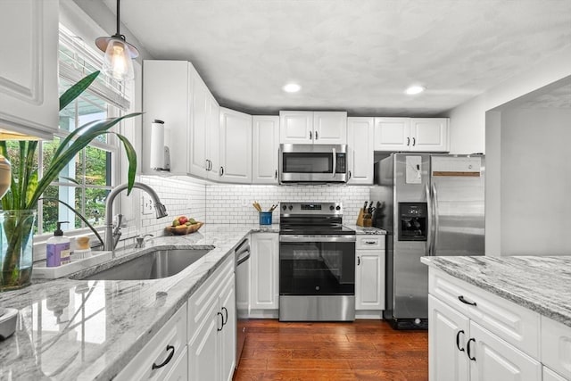 21 Forest St, Wilmington, MA 01887 - kitchen featuring stainless steel appliances, a sink, dark wood-style floors, white cabinets, and tasteful backsplash