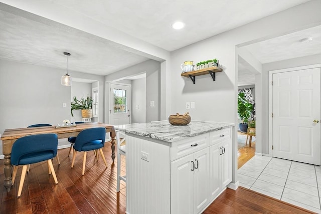 21 Forest St, Wilmington, MA 01887 - kitchen with white cabinetry, light wood finished floors, light stone counters, pendant lighting, and open shelves
