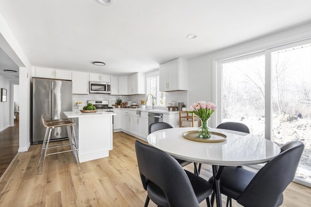 dining area with light wood-style flooring and recessed lighting