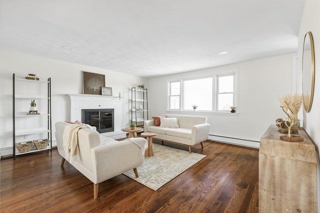 living area with a fireplace, dark wood finished floors, and baseboard heating