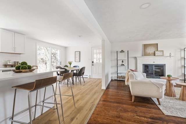 living room featuring a fireplace, wood finished floors, and baseboards