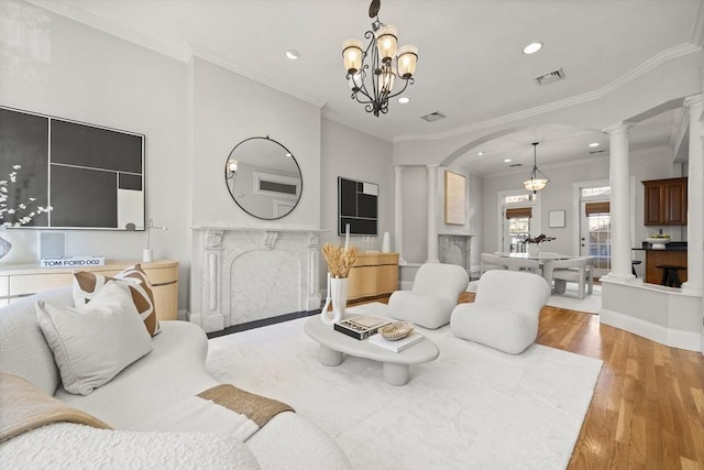 living room featuring ornamental molding, light hardwood / wood-style flooring, and a chandelier