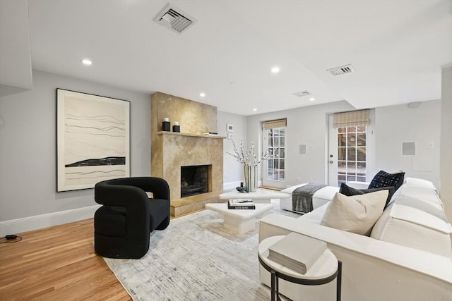 living room with a large fireplace and wood-type flooring